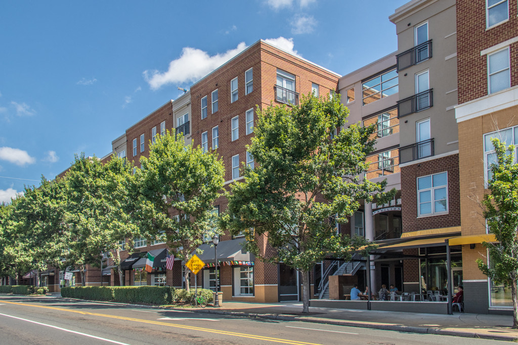 a large brick building on a city street with trees