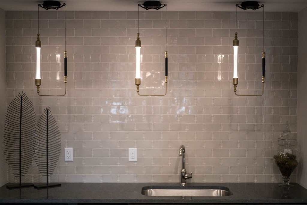 the kitchen has a large sink and lights on the wall