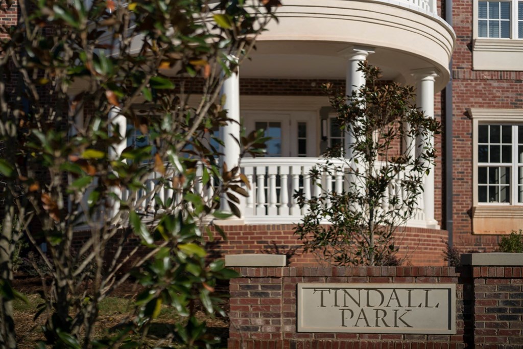 a sign for tisdall park in front of a brick building