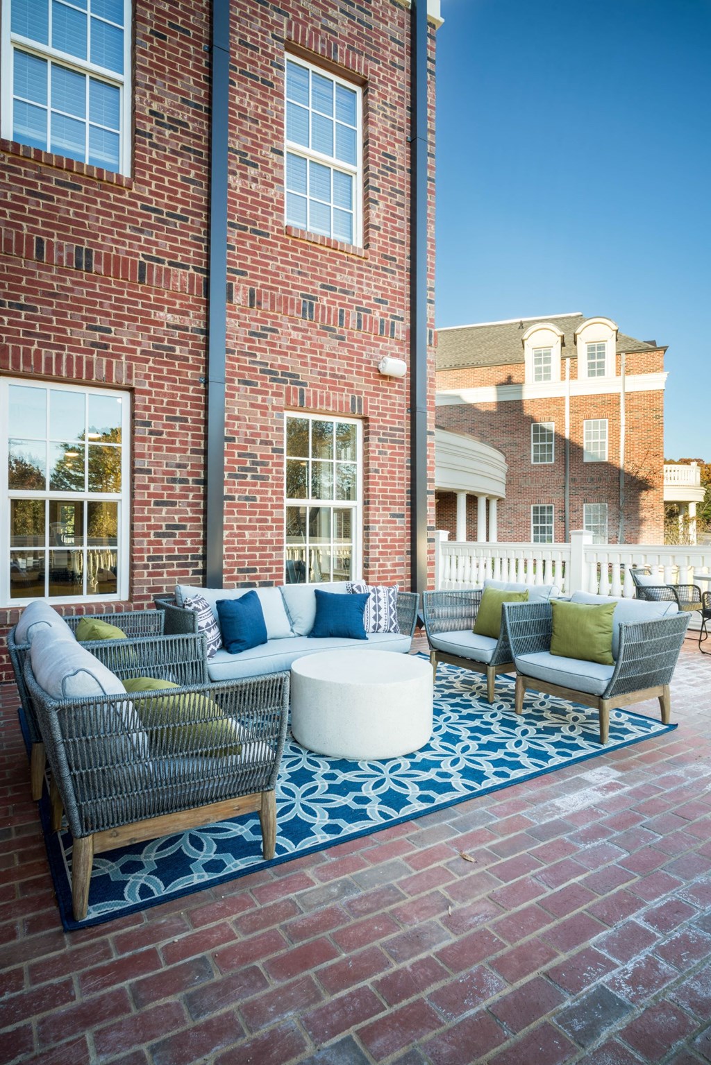 a patio with a couch and chairs in front of a brick building