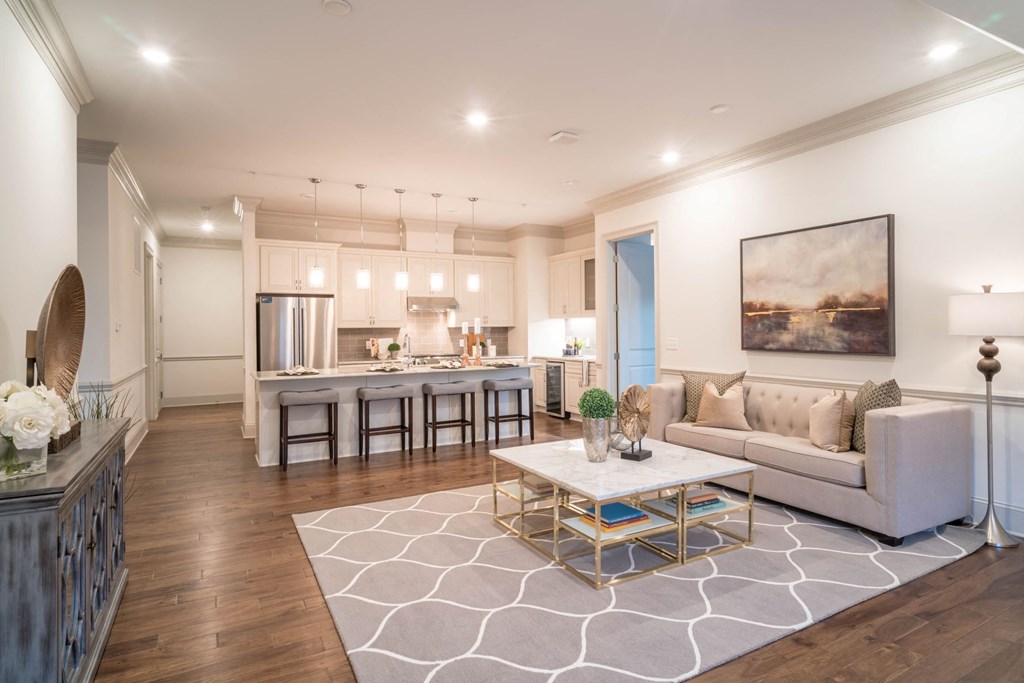 a living room with a couch and a table in front of a kitchen