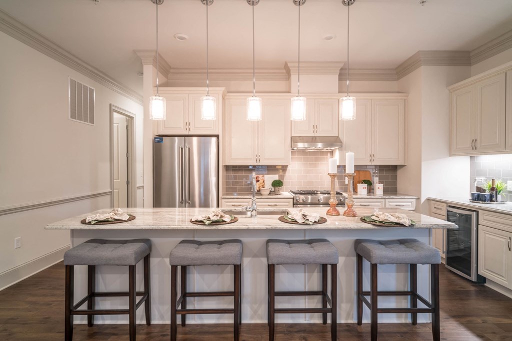a kitchen with a large island with three stools in front of it