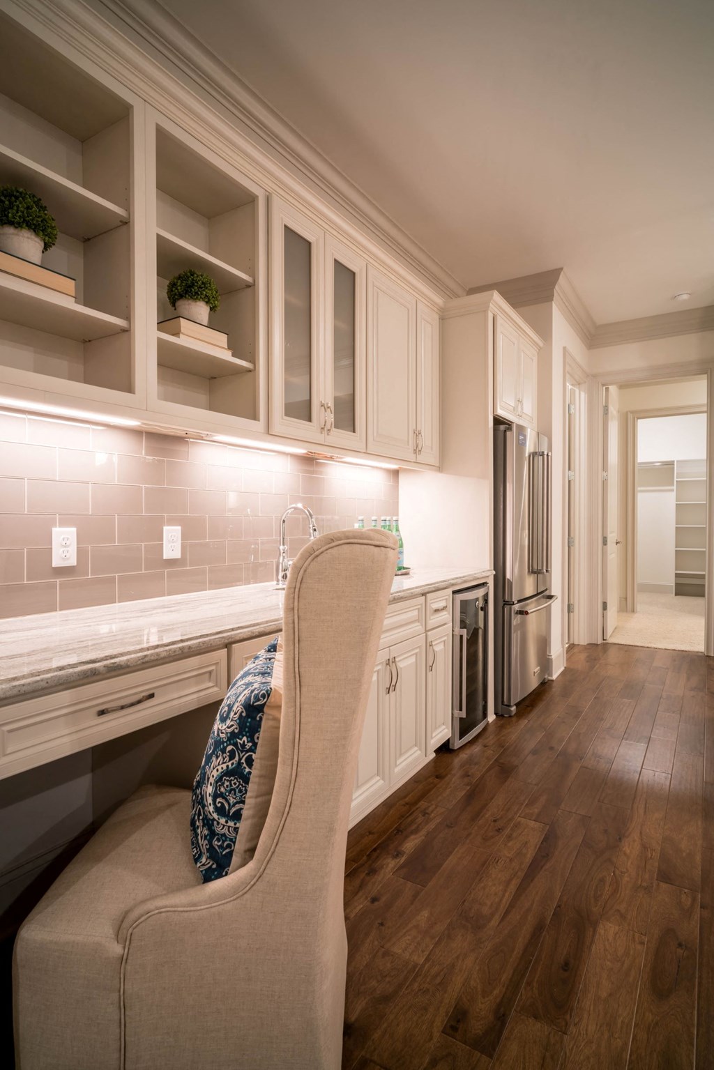 a kitchen with white cabinets and a chair