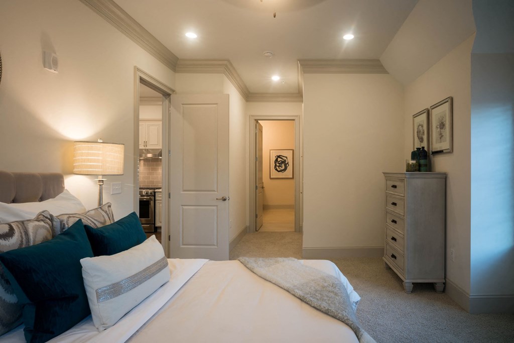 a bedroom with a bed and a hallway to a bathroom