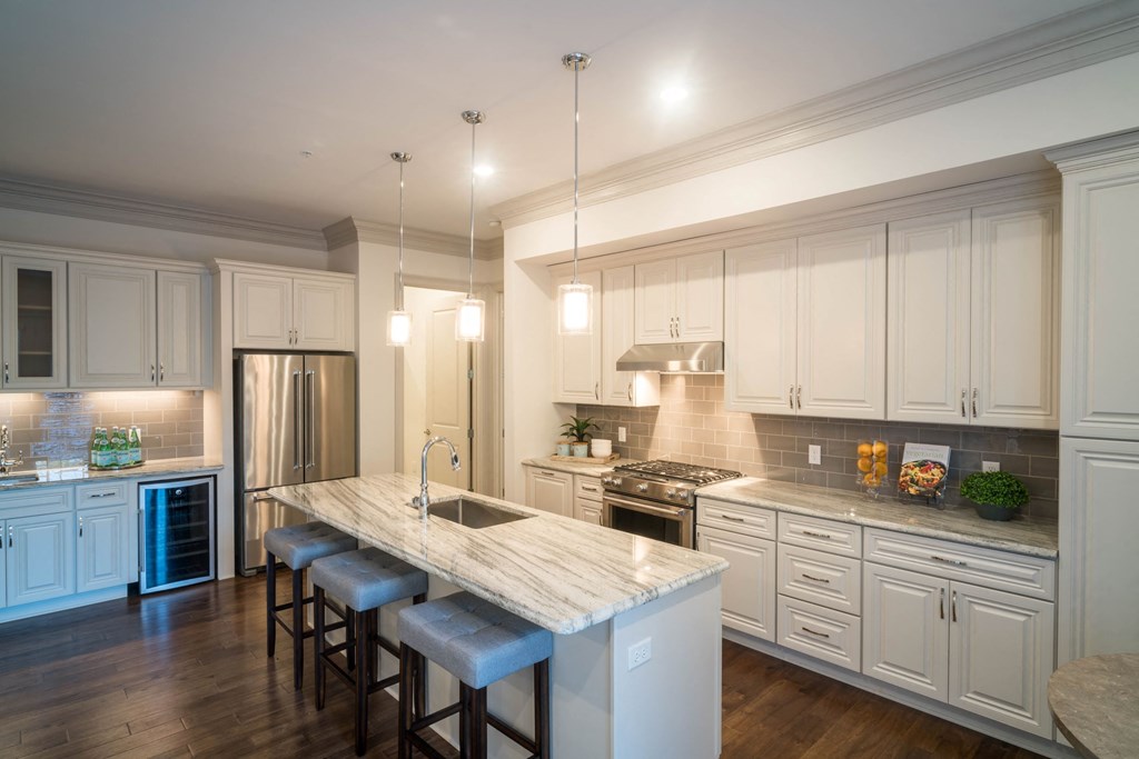 a large kitchen with white cabinets and a marble counter top