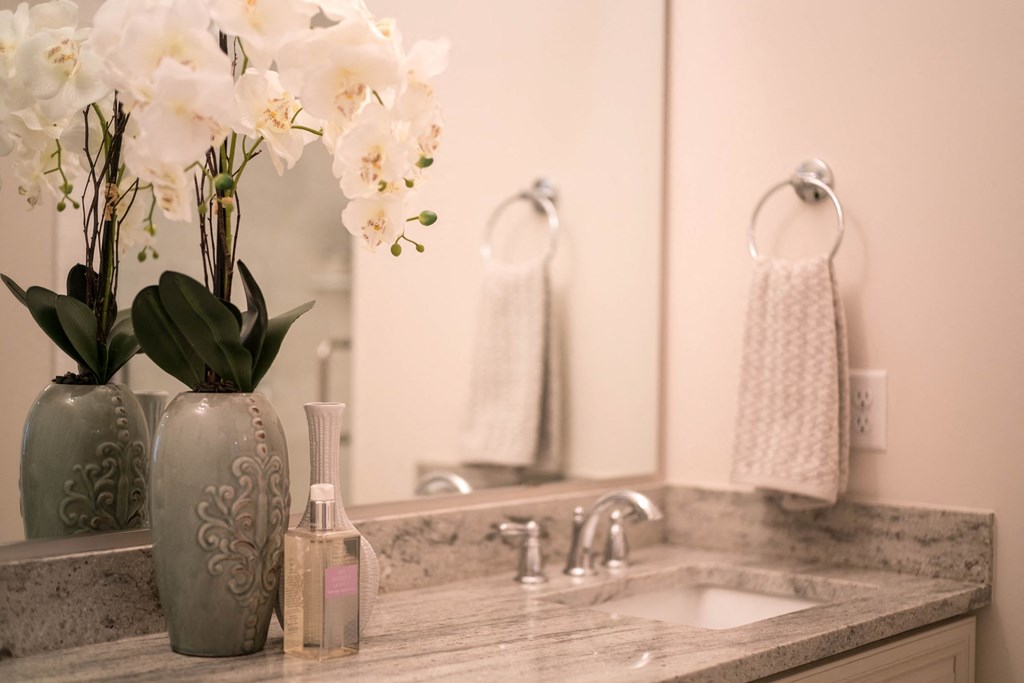 a bathroom with a sink and a vase with flowers