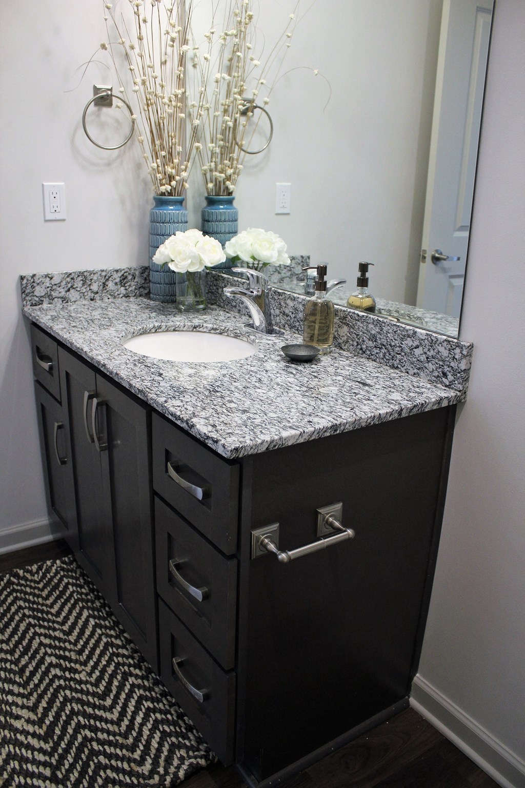a bathroom with granite counter top and a sink