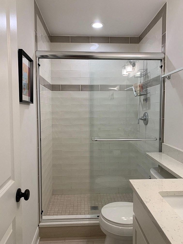 a bathroom with a shower and a toilet and a sink