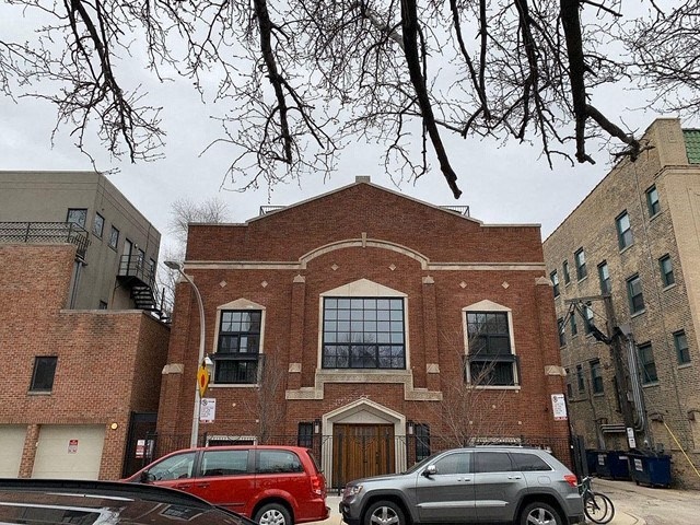 a brick building with cars parked in front of it