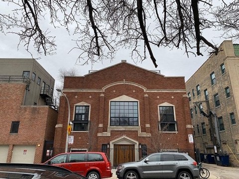 a brick building with cars parked in front of it