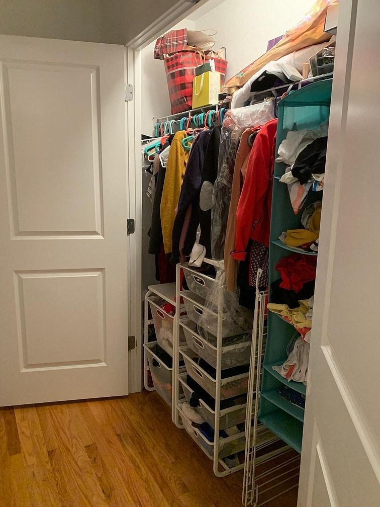 a closet with a rack of clothes in it and a door
