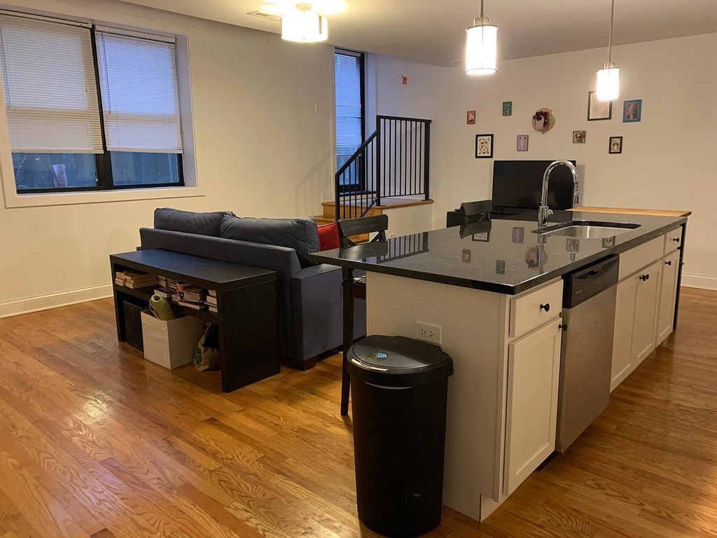 an empty living room with a kitchen and a couch