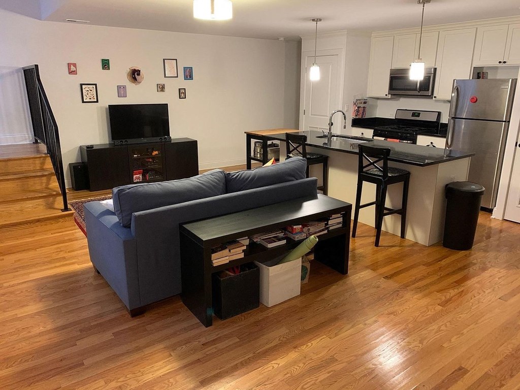 a living room and kitchen with a couch and a table