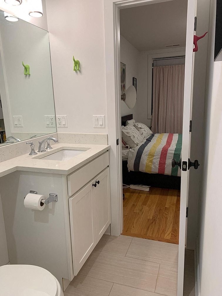 a bathroom with a sink and a toilet and a bed