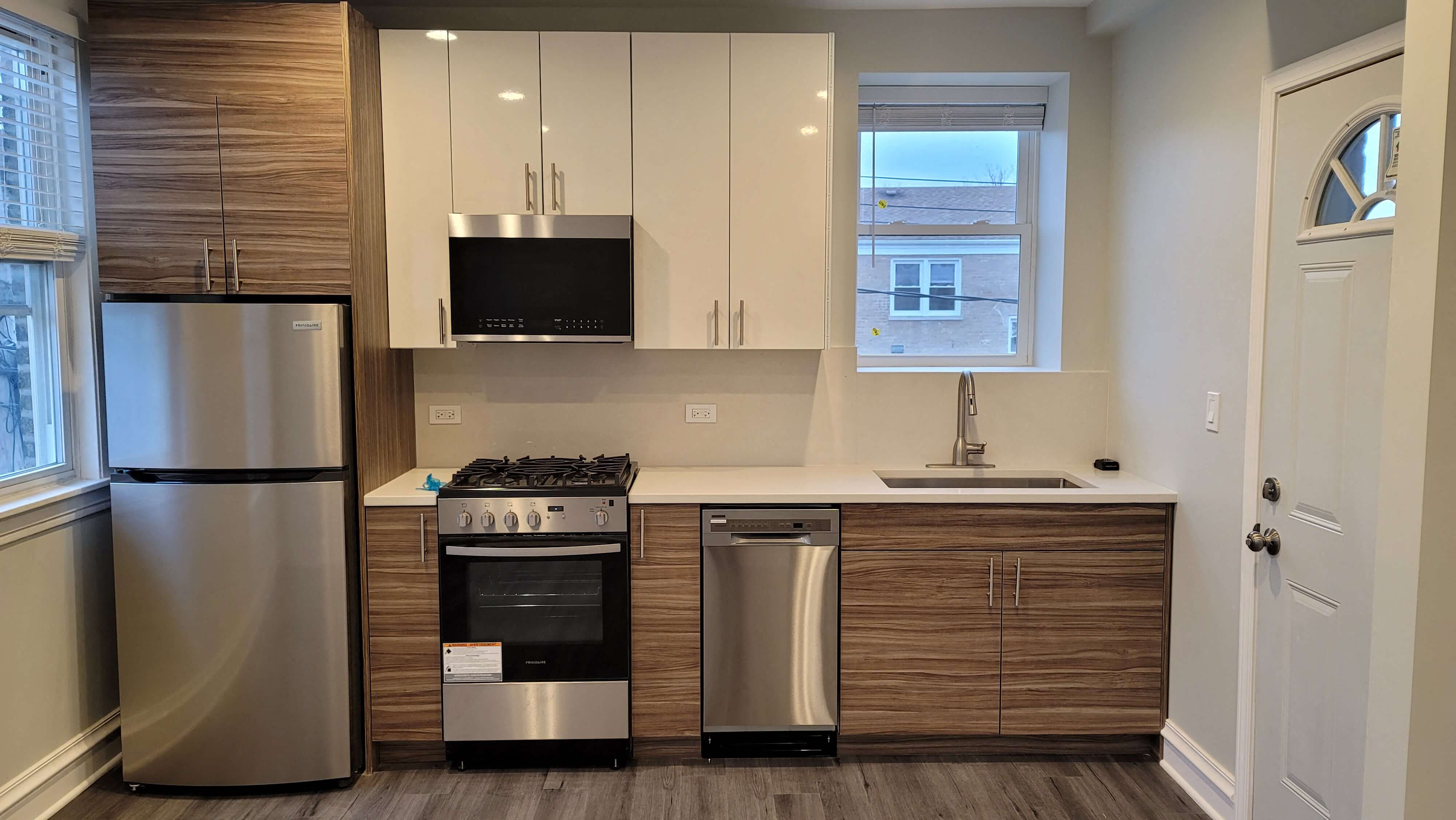 A modern kitchen with stainless steel appliances and wooden cabinets.