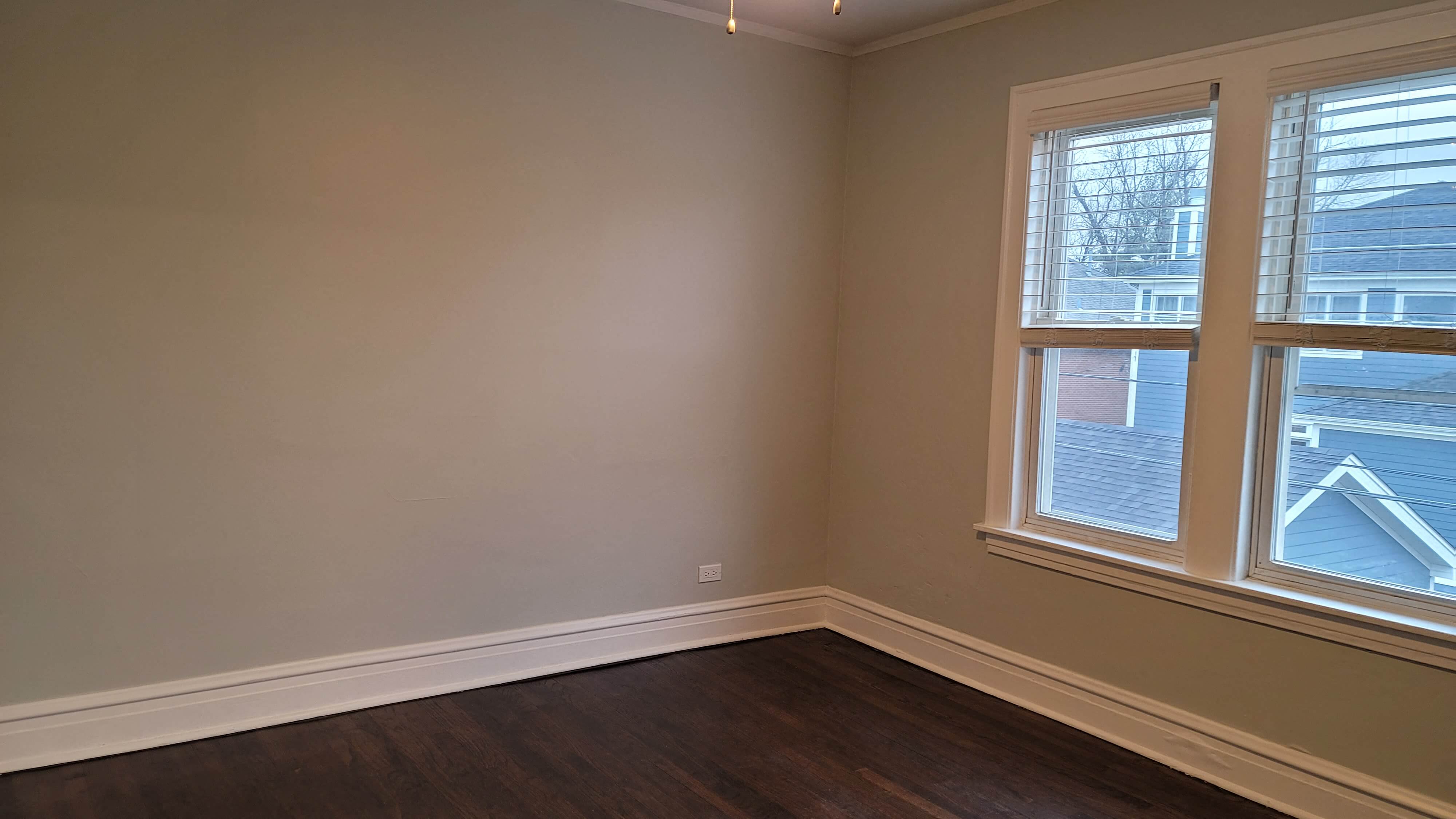 A room with a window and wooden floors.