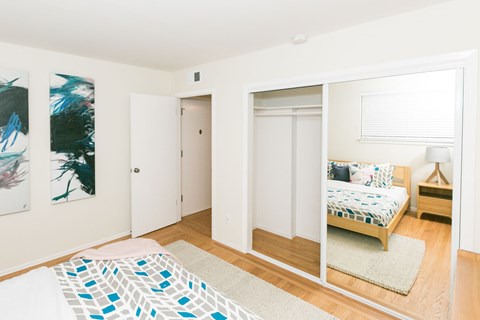 A bedroom with a bed and a painting on the wall.