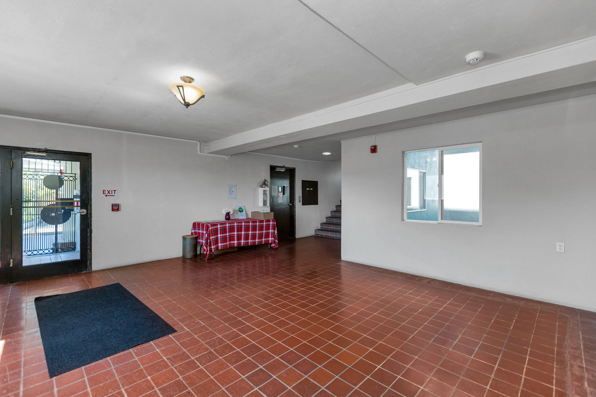A room with a red tile floor and white walls.