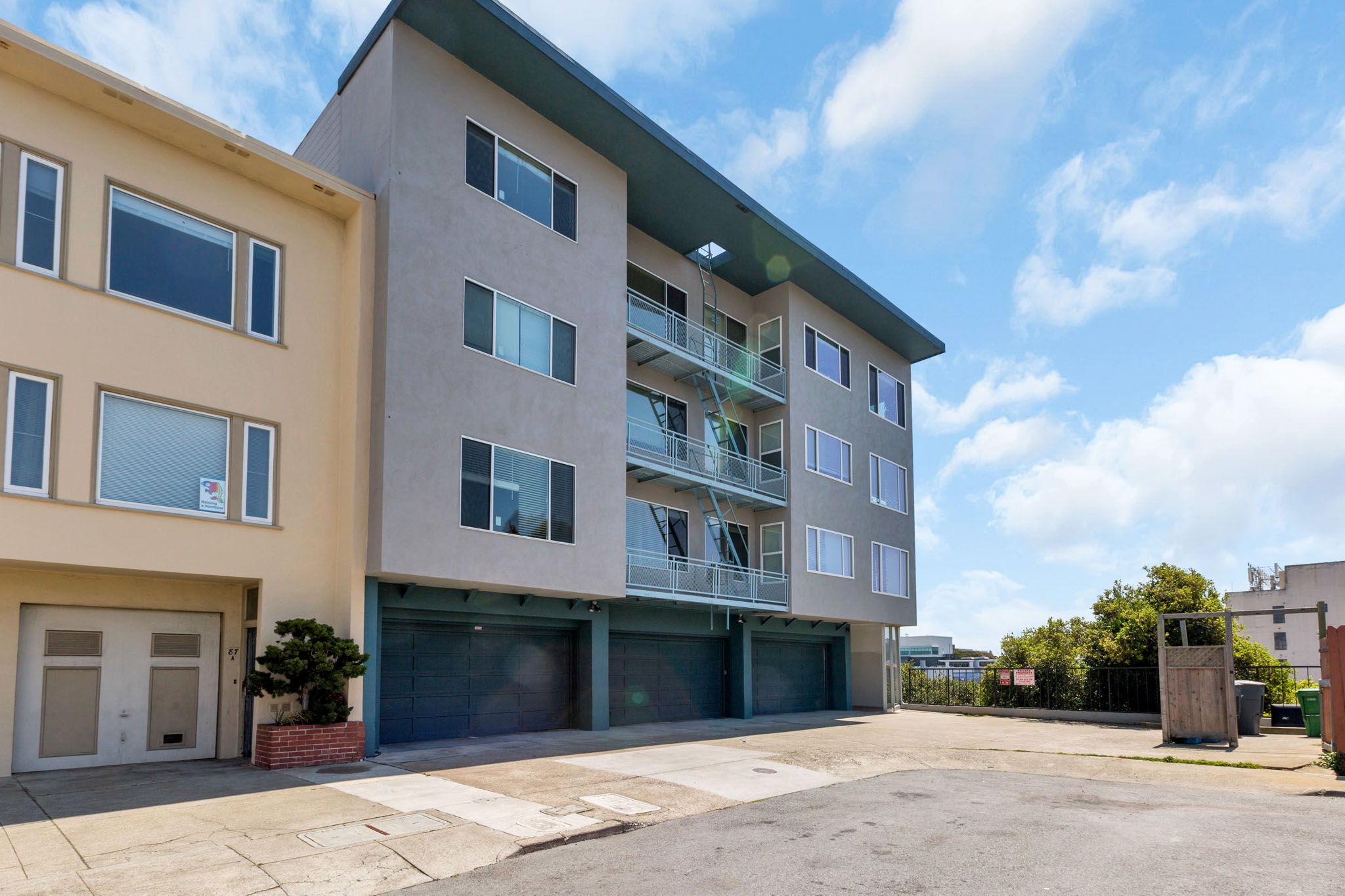 A modern two-story apartment building with a garage door and balconies.