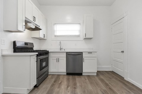 A kitchen with white cabinets and a black stove top oven.