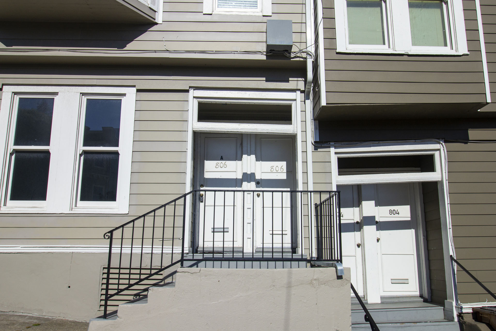 A house with a white door and a black railing.