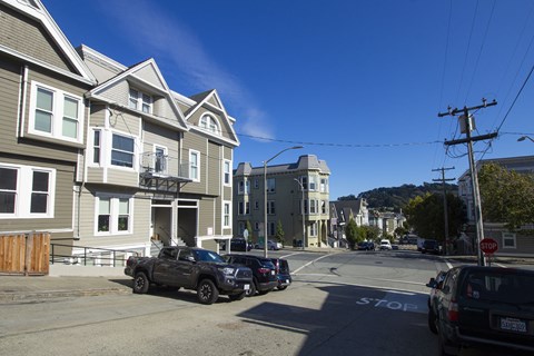A street view with cars and buildings on a sunny day.