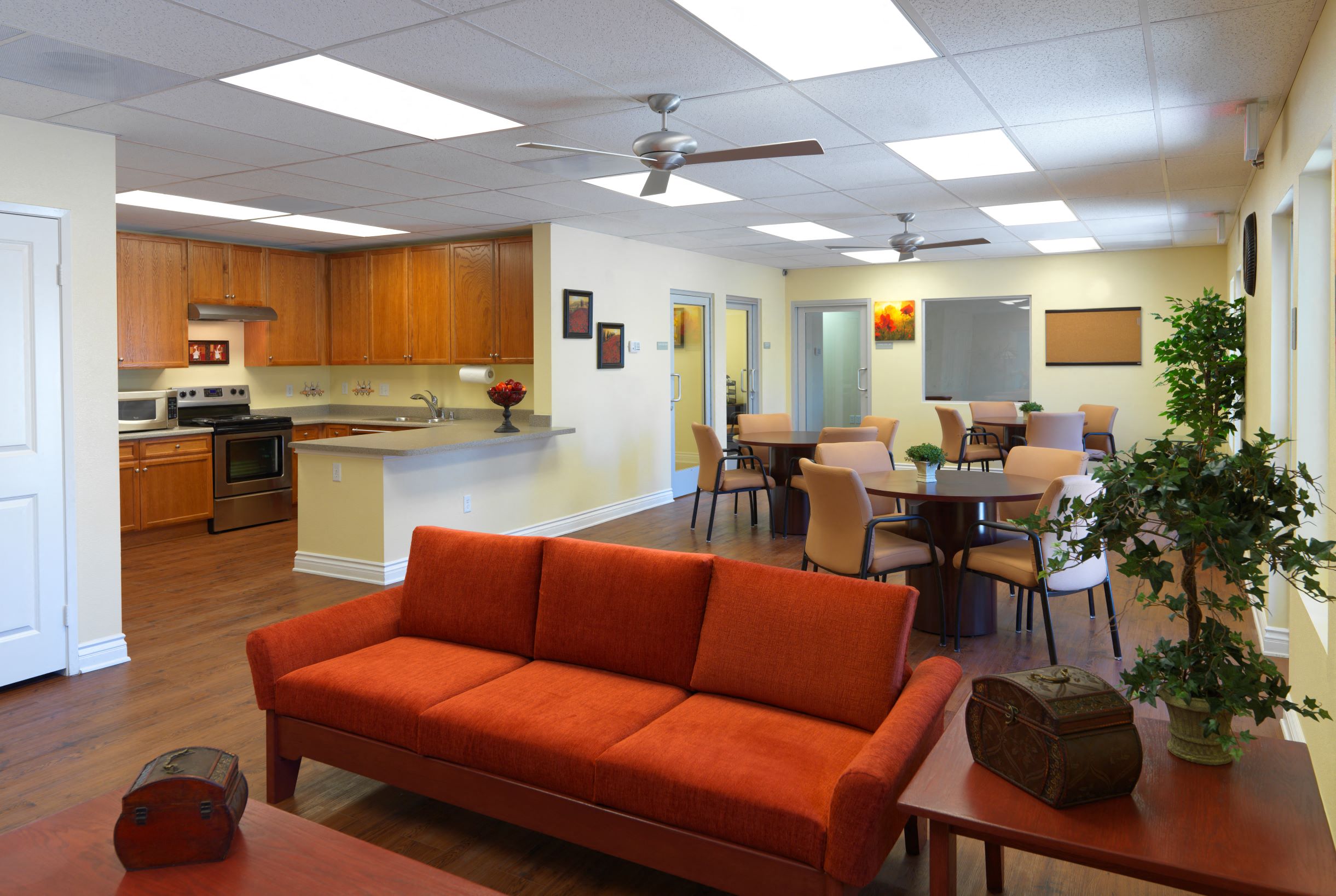 a living room with an orange couch in front of a kitchen and dining room