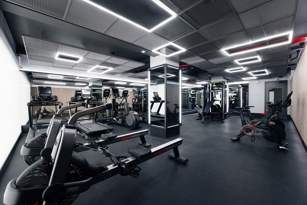 a gym with various exercise equipment and lights on the ceiling