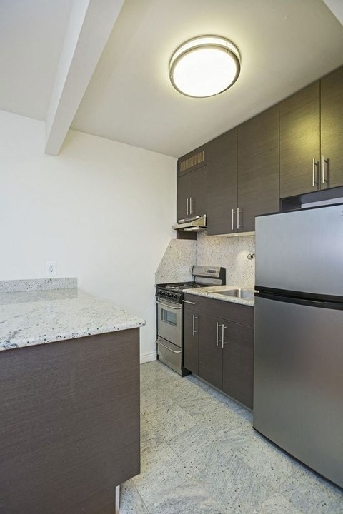 a kitchen with stainless steel appliances and marble counter tops