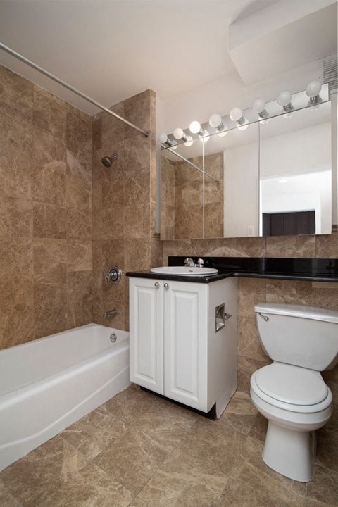 a bathroom with a toilet and a tub and a sink