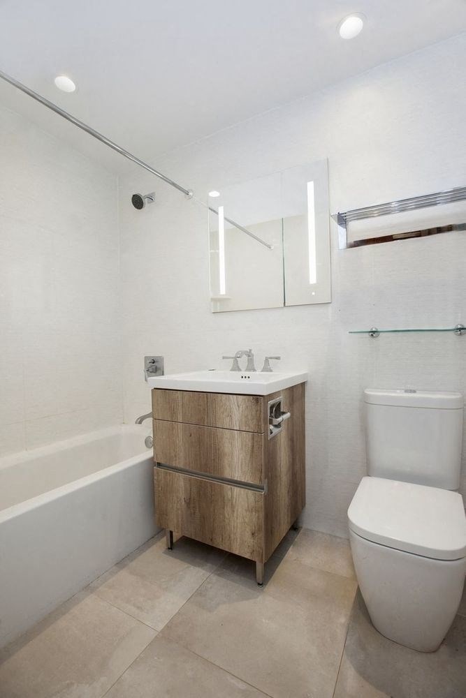 a bathroom with a toilet and a sink and a bath tub