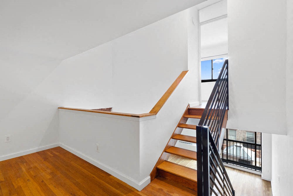 a stairwell in a home with wood floors and white walls