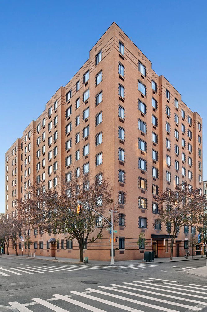 a tall brick building on the corner of a city street