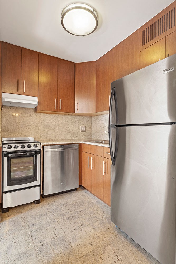 a kitchen with stainless steel appliances and wooden cabinets