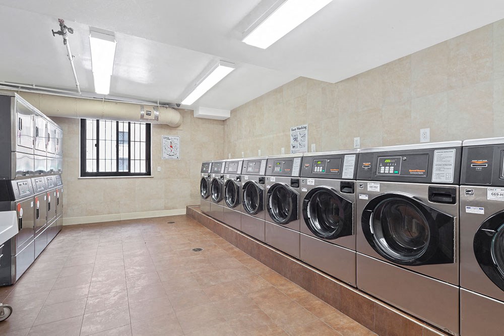 a laundry room with a row of washing machines