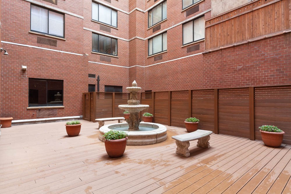 a courtyard with a fountain and a brick building