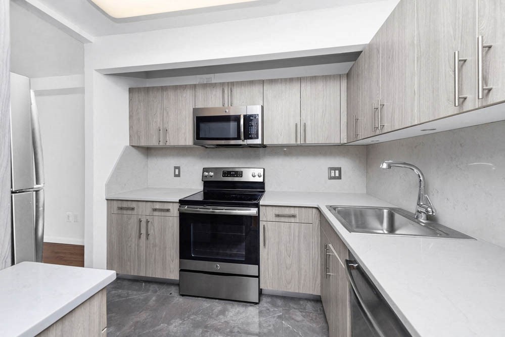 a kitchen with stainless steel appliances and white counter tops