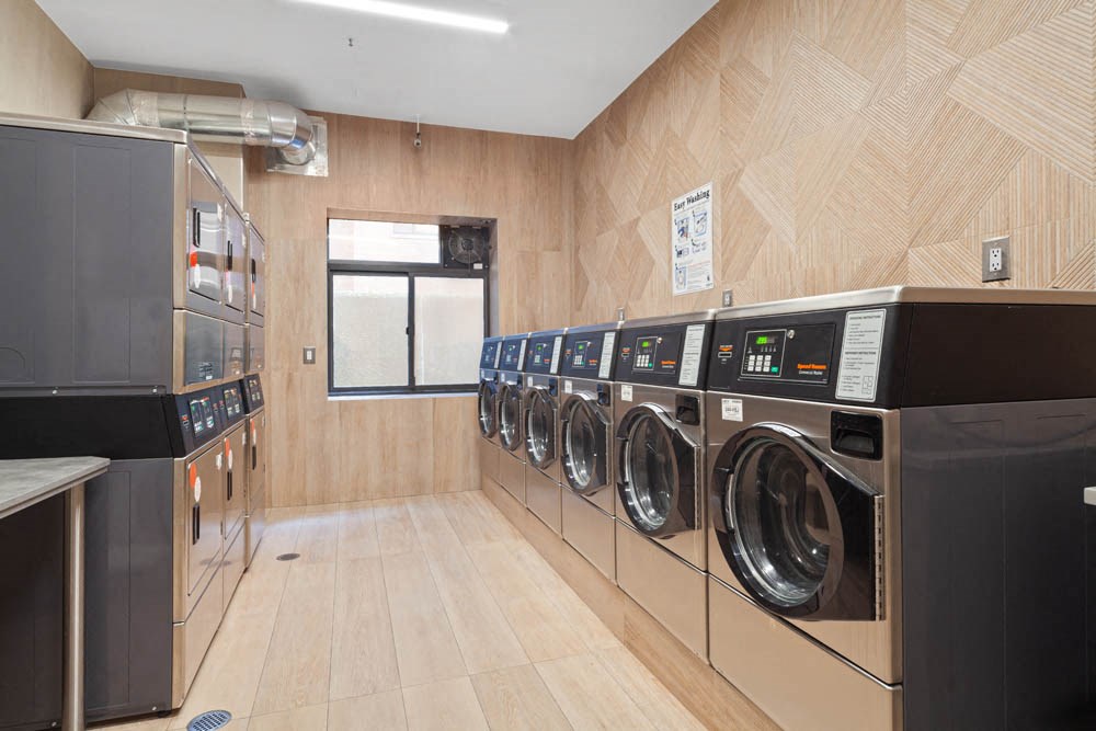 a washer and dryer in a laundry room with wooden walls and wooden floors