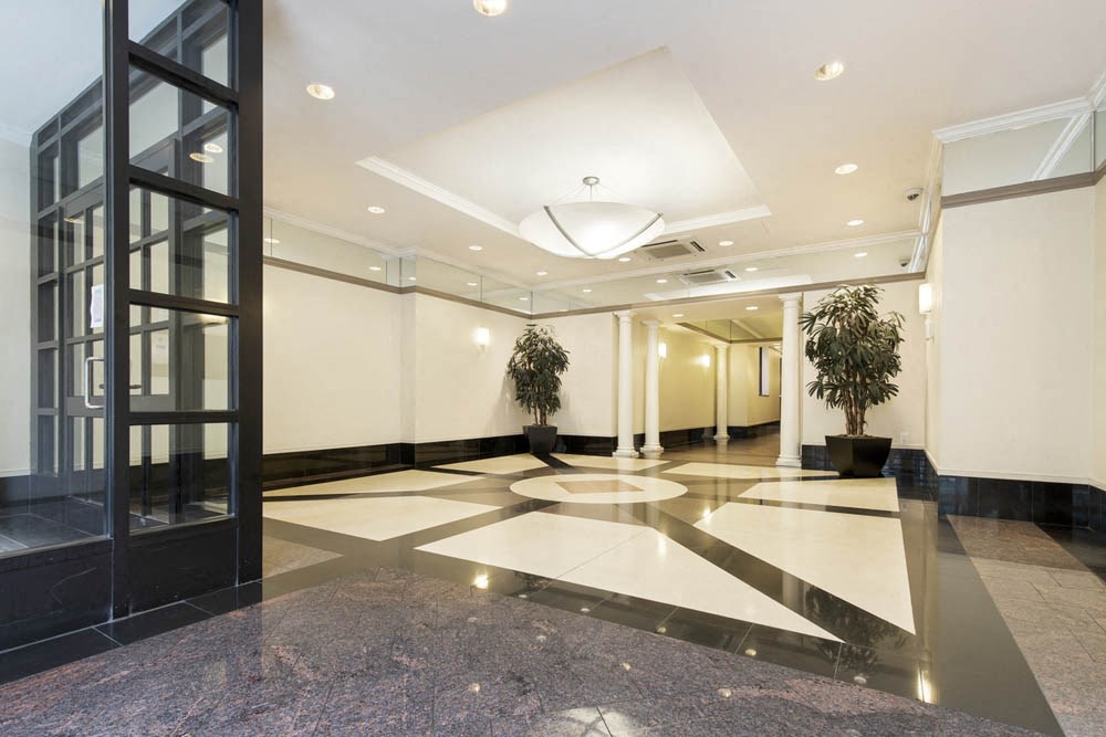a large lobby with a door and a large plant