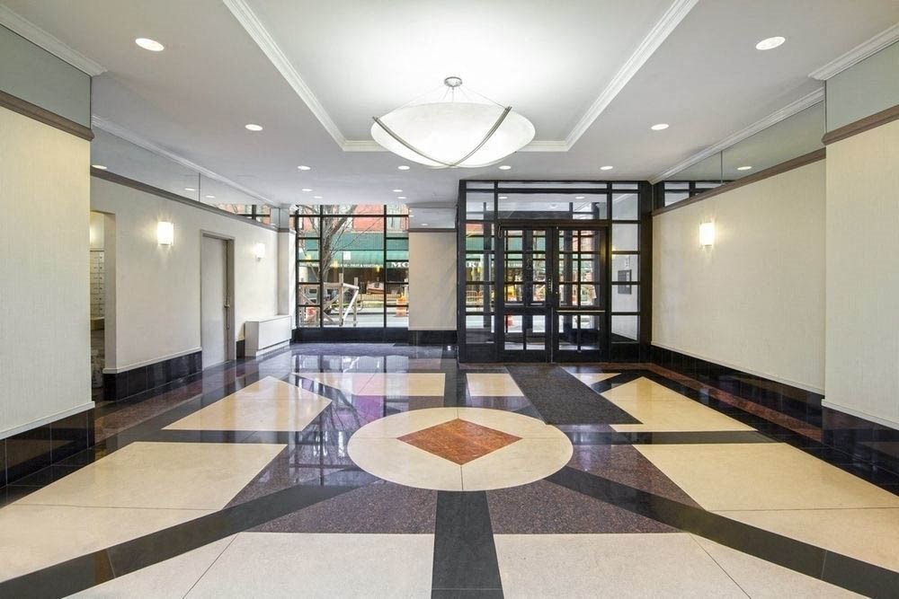 the lobby of the building has a large marble floor with a geometric design