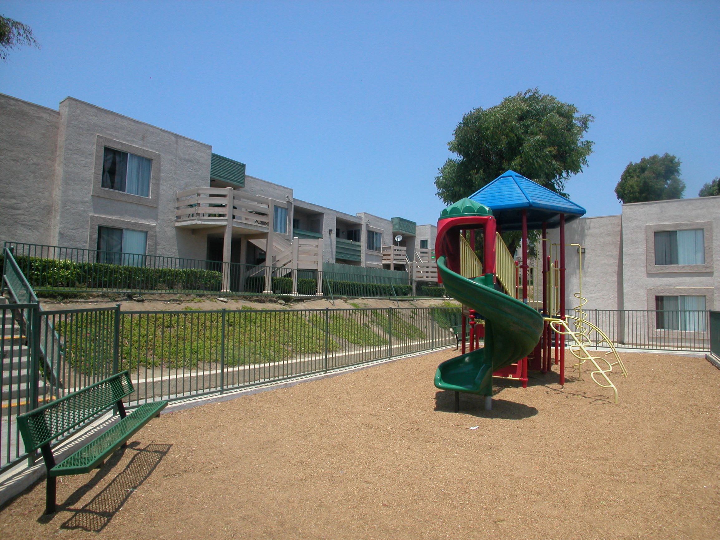 a playground with a slide in front of some apartments