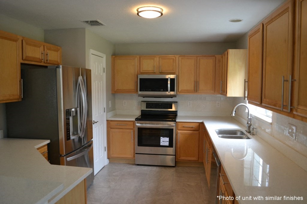 A kitchen with wooden cabinets and stainless steel appliances.
