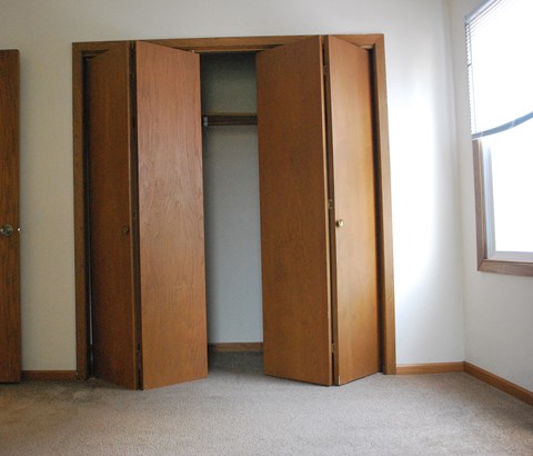 an empty closet in a room with a window