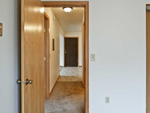 a bedroom door open to a hallway with a door to a closet