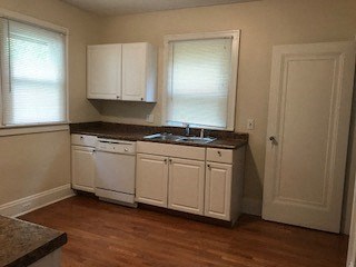 a small kitchen with white cabinets and a sink