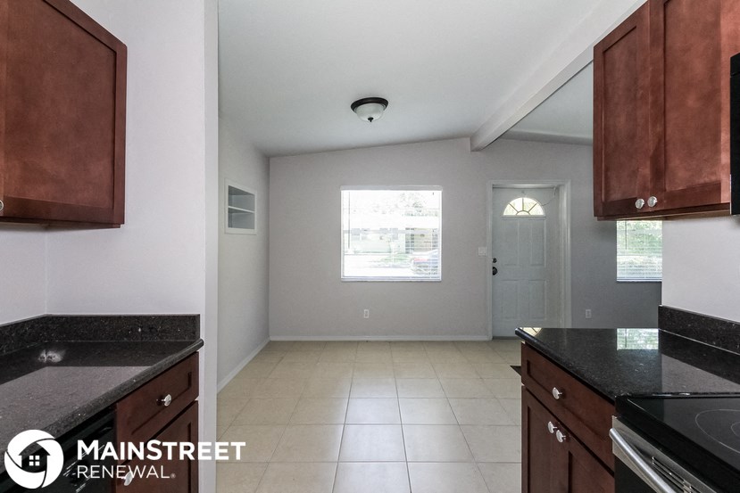 a kitchen with black counter tops and wooden cabinets