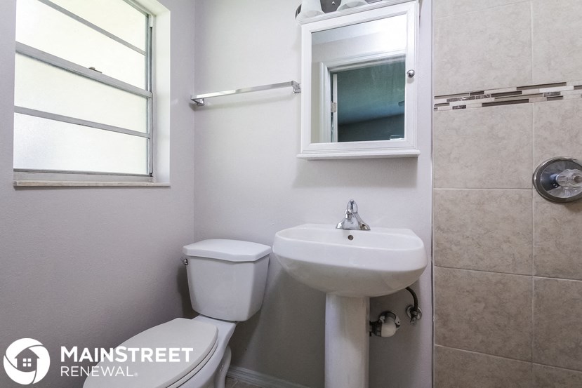 a small bathroom with a sink and toilet and a window