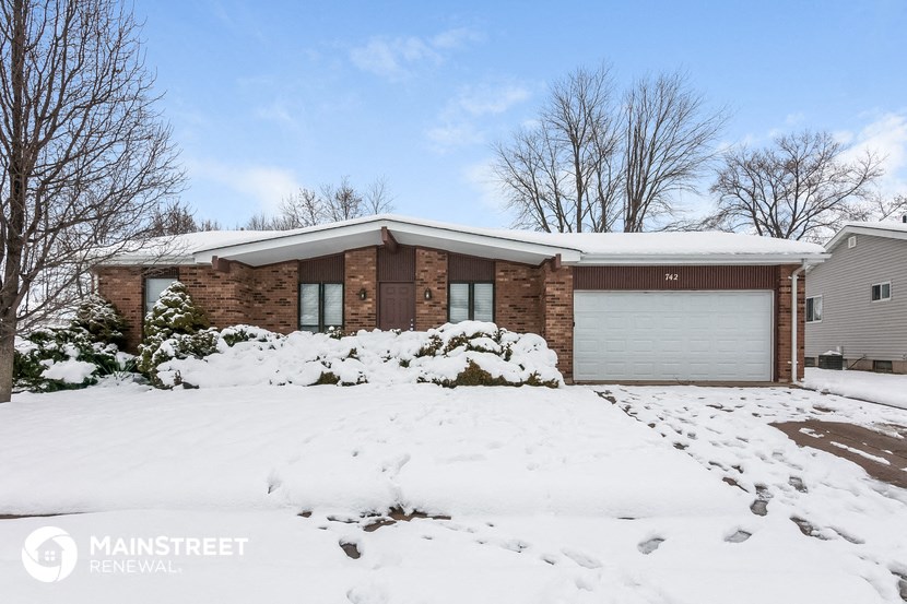 a house covered in snow with a garage door