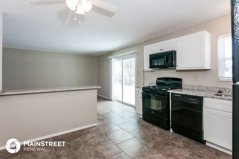 a kitchen with black appliances and white cabinets