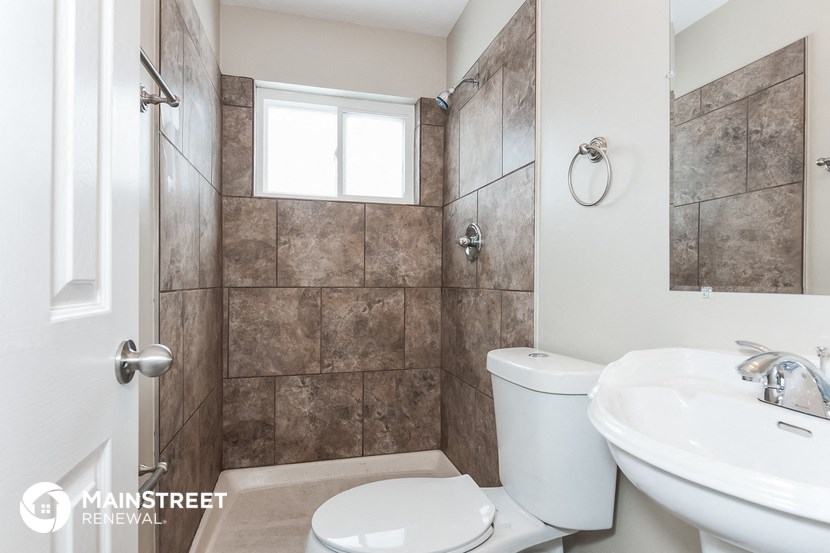 a bathroom with a toilet and a sink and a shower